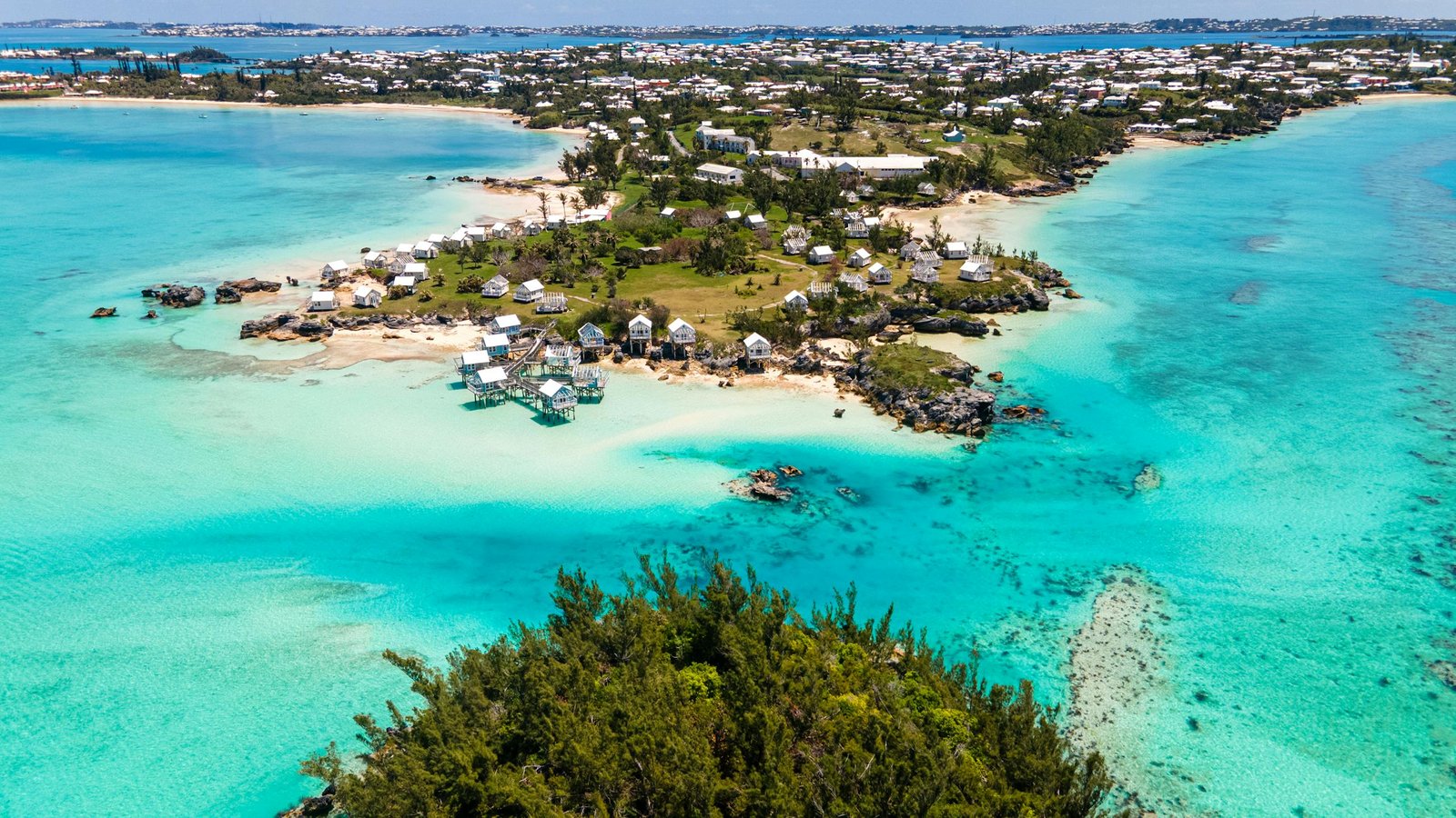 A stunning aerial shot capturing Bermuda's coastline with vibrant turquoise waters and charming houses.