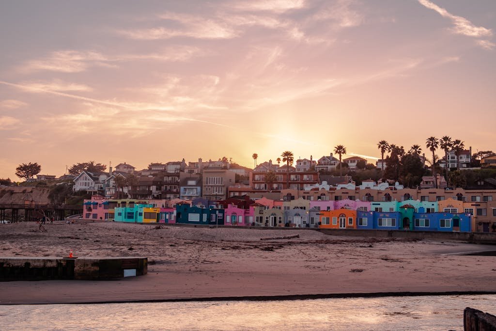 Vibrant beach houses along Capitola shore at sunset, capturing a warm, tranquil vibe.