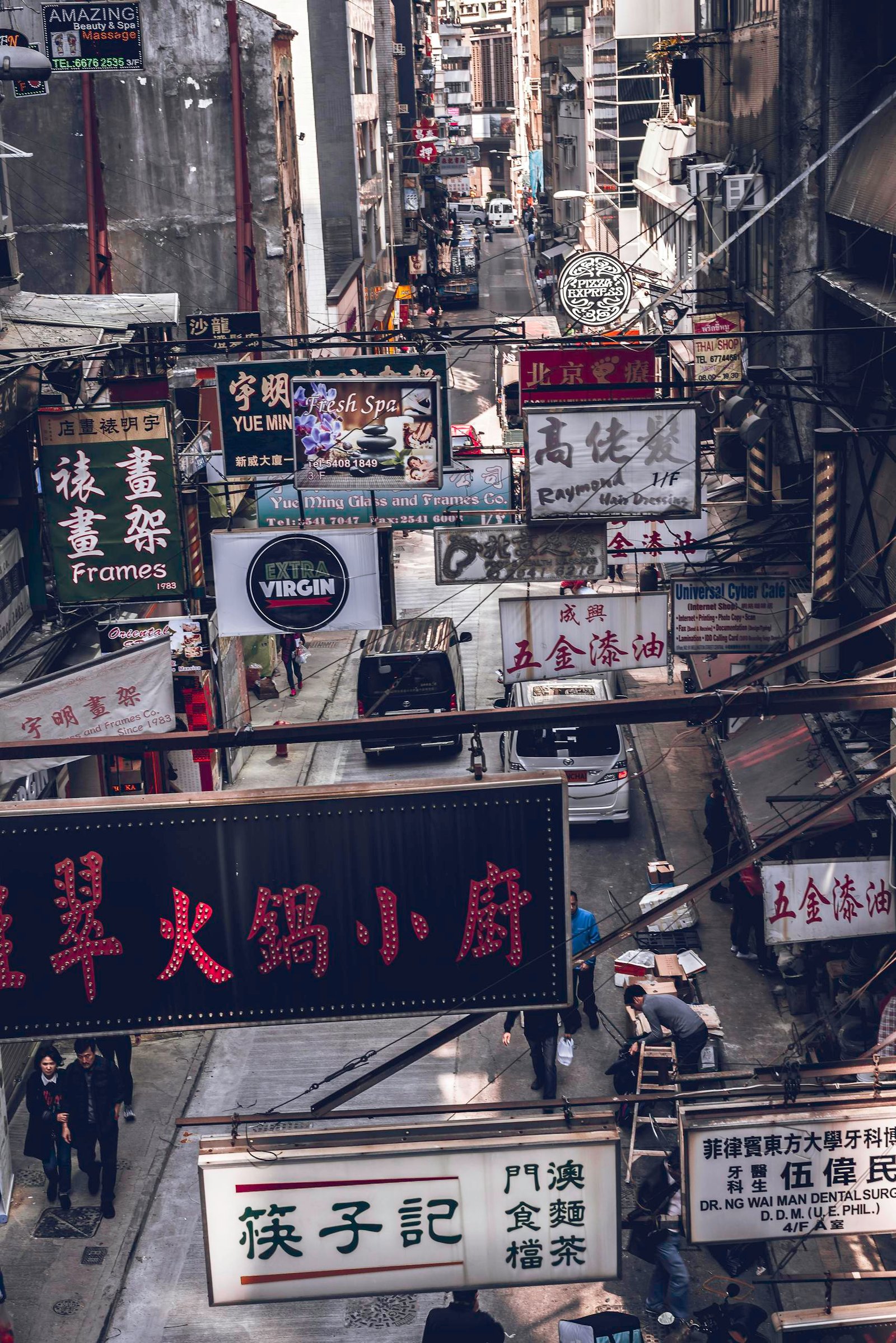Bustling street in downtown Hong Kong filled with neon signs and urban activity.
