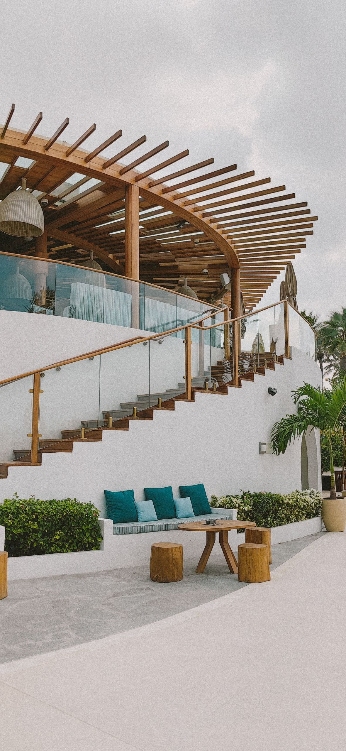 Stylish modern villa featuring a spiral wooden staircase and outdoor seating area.