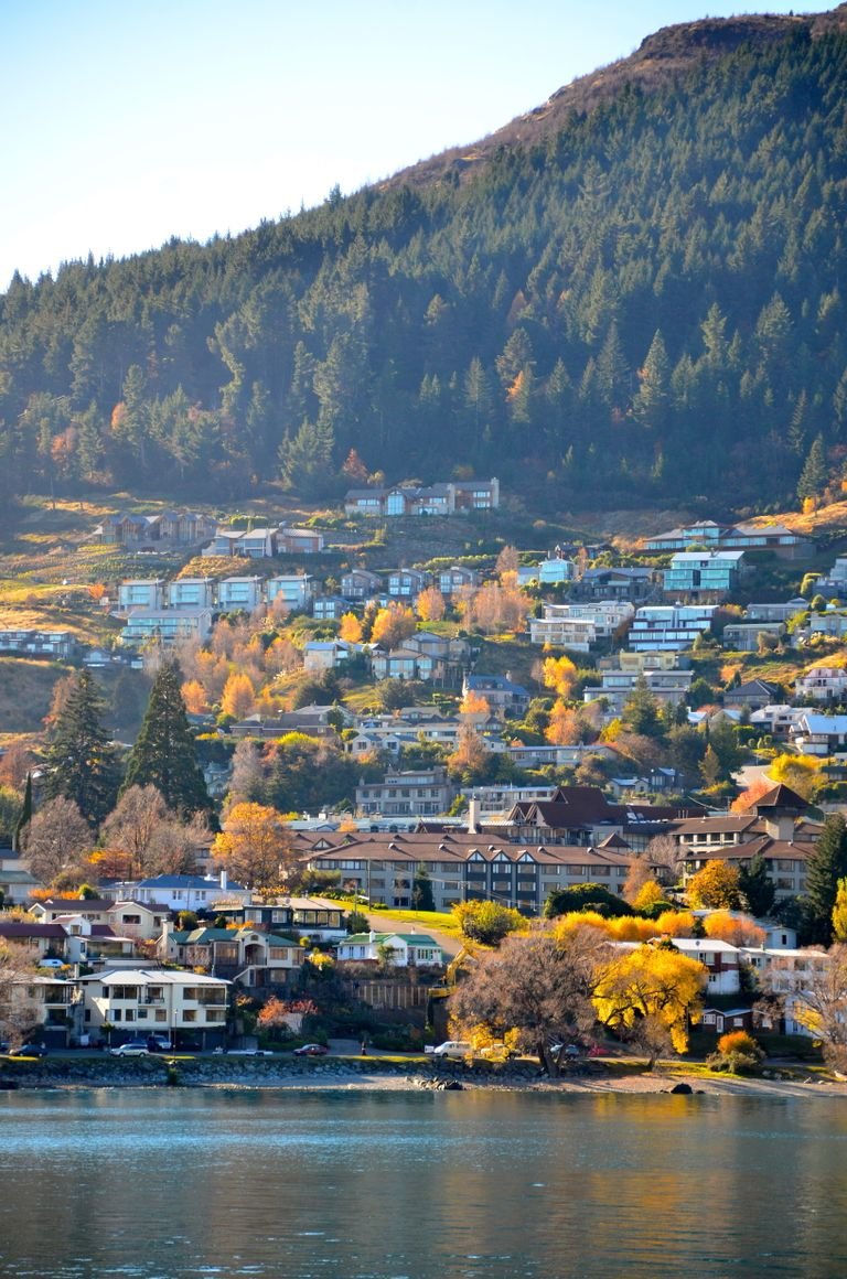 A stunning autumn landscape of Queenstown, New Zealand, with colorful foliage and mountain backdrop.