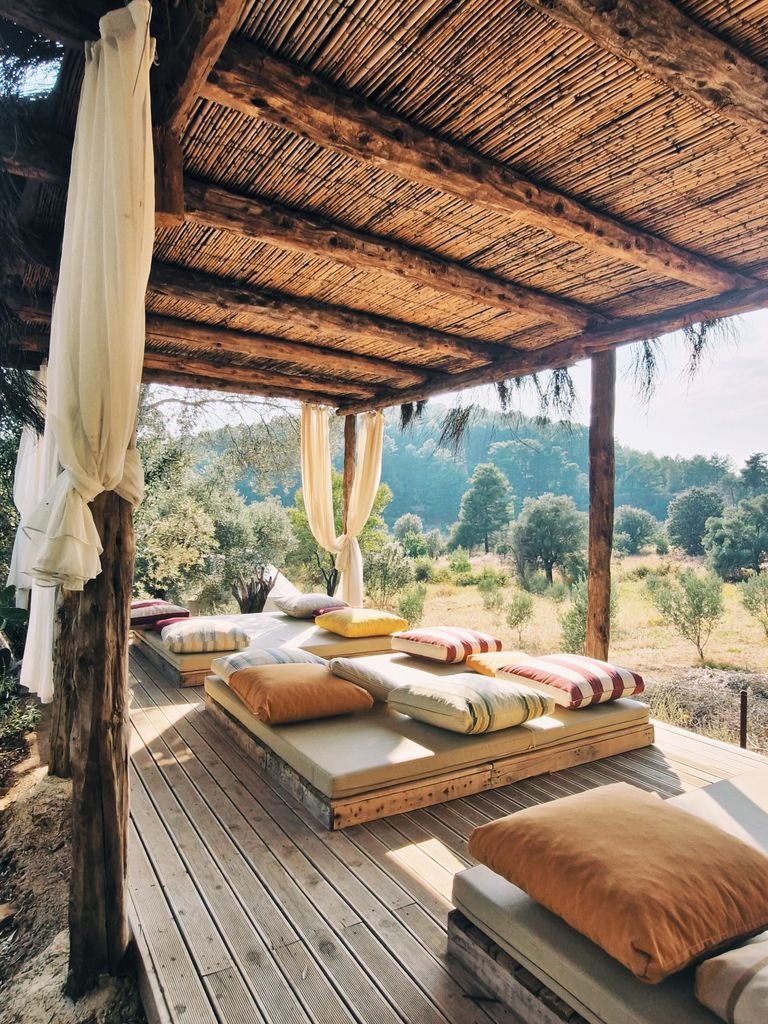 Cozy outdoor lounge with wooden decor set amidst nature in Muğla, Türkiye.