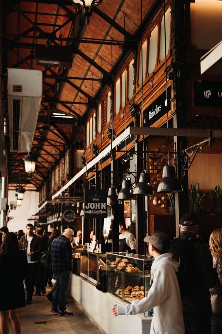 Experience the vibrant atmosphere of Mercado de San Miguel in Madrid, with diverse food stalls and lively shoppers.