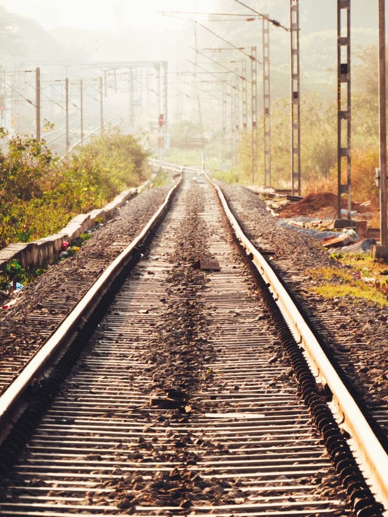 Serene railway tracks with sunlight in the urban landscape of Bengaluru, India.